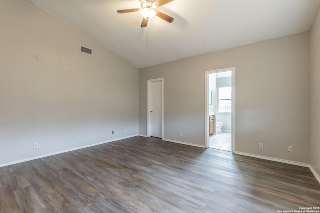 empty room featuring ceiling fan, vaulted ceiling, and dark hardwood / wood-style flooring