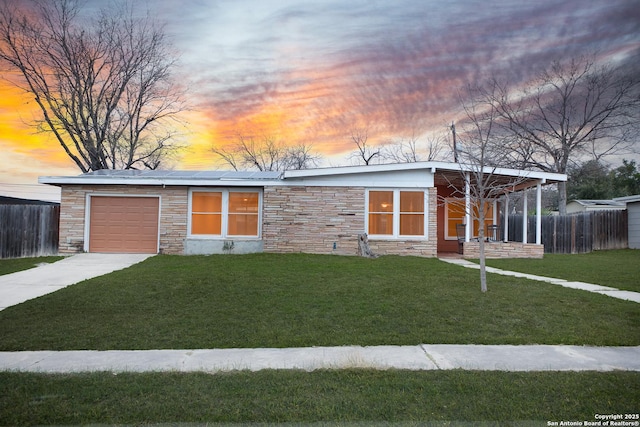 single story home with a garage and a lawn