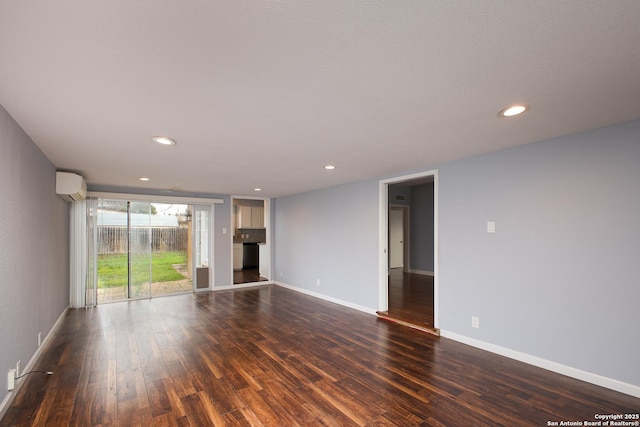 unfurnished living room with dark hardwood / wood-style flooring and an AC wall unit