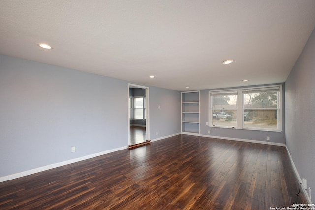 unfurnished room featuring built in features and dark wood-type flooring