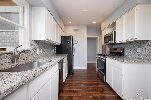 kitchen featuring sink, stainless steel appliances, white cabinets, and light stone counters