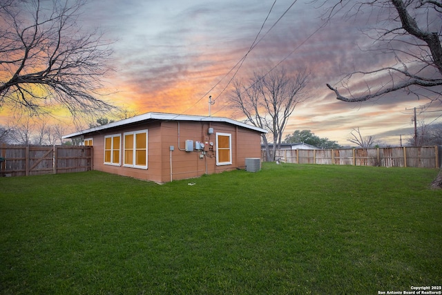 property exterior at dusk featuring a lawn and central air condition unit