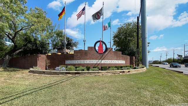 community / neighborhood sign featuring a lawn