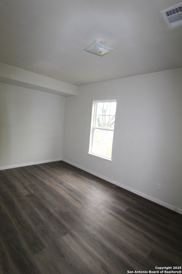 empty room with dark hardwood / wood-style flooring