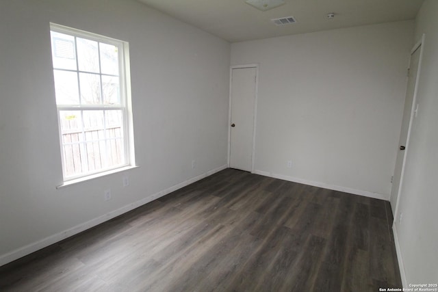 spare room with dark wood-type flooring