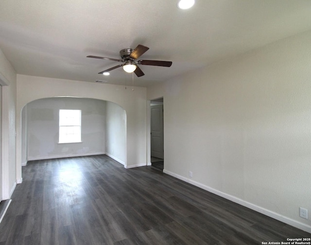 empty room featuring ceiling fan and dark hardwood / wood-style flooring