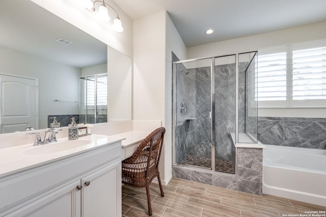 full bathroom featuring a stall shower, visible vents, vanity, and a bath