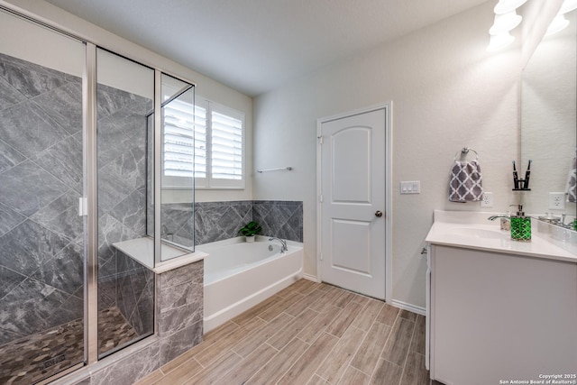 full bathroom featuring a shower stall, wood finish floors, a bath, and vanity