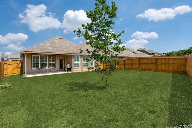 back of property with a patio, a lawn, and a fenced backyard