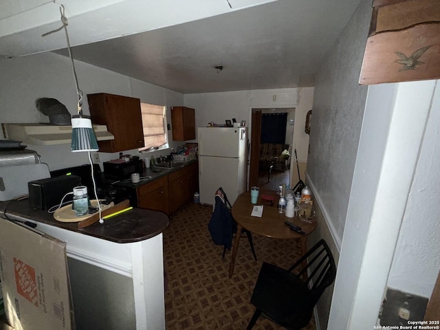 kitchen with sink and white fridge