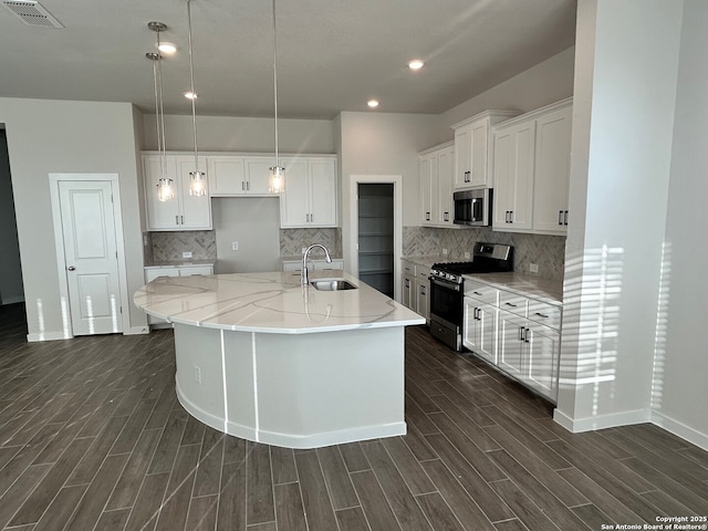 kitchen with white cabinets, an island with sink, stainless steel appliances, and sink