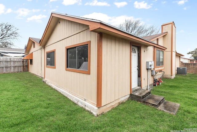 exterior space featuring central AC unit and a lawn