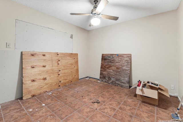 unfurnished room with ceiling fan and a textured ceiling