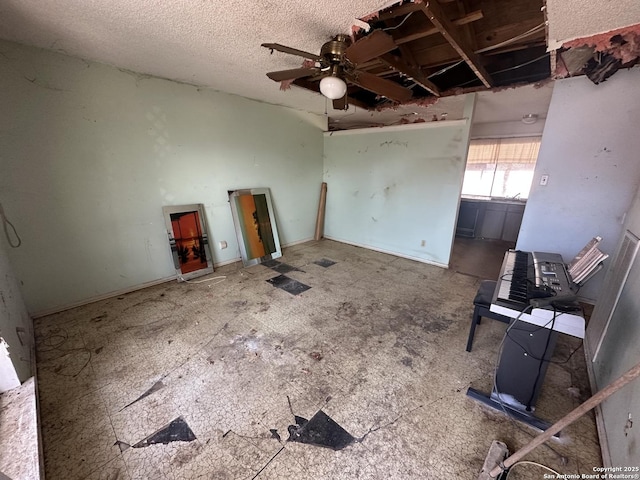 unfurnished room featuring ceiling fan and a textured ceiling