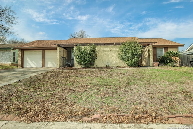 ranch-style house featuring a garage and a front lawn