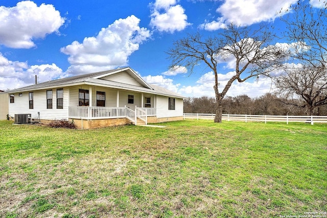 back of property featuring covered porch, central air condition unit, and a yard