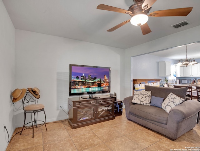 tiled living room with ceiling fan with notable chandelier