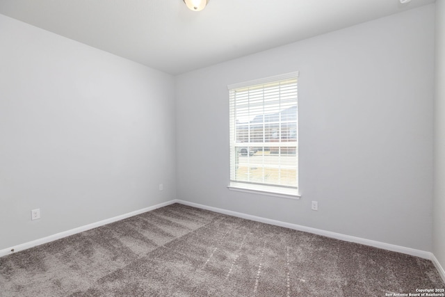 carpeted empty room featuring baseboards