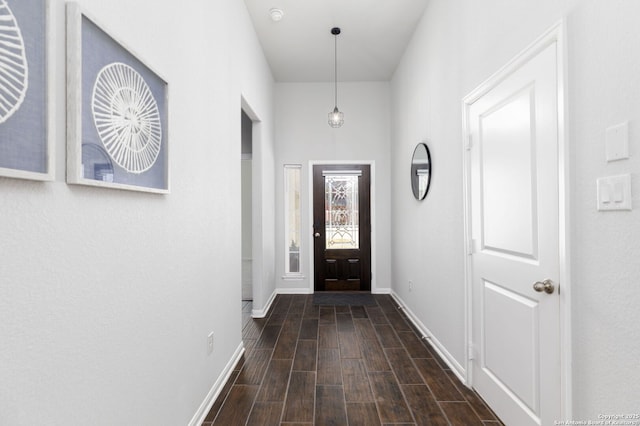 entryway with dark wood finished floors and baseboards