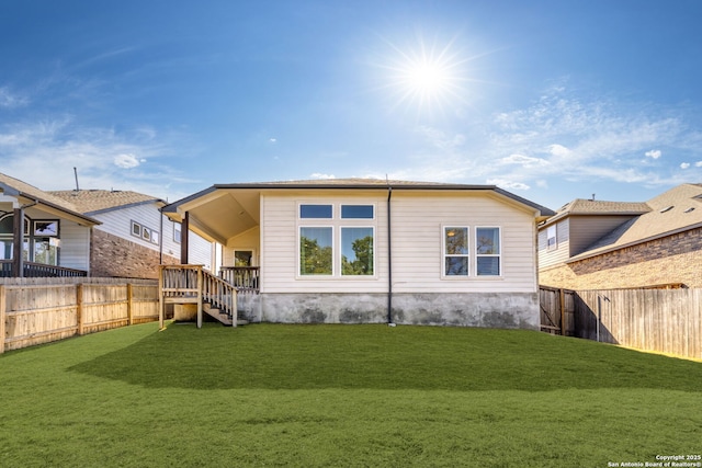 back of house with a lawn and a fenced backyard