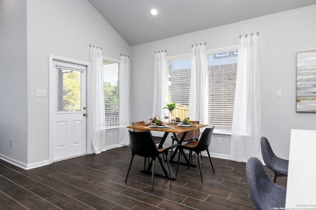 dining area with wood tiled floor, baseboards, and vaulted ceiling