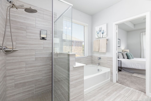 bathroom featuring a garden tub, ensuite bath, and a shower stall