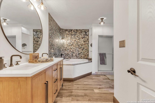 bathroom featuring hardwood / wood-style flooring, vanity, and a tub to relax in