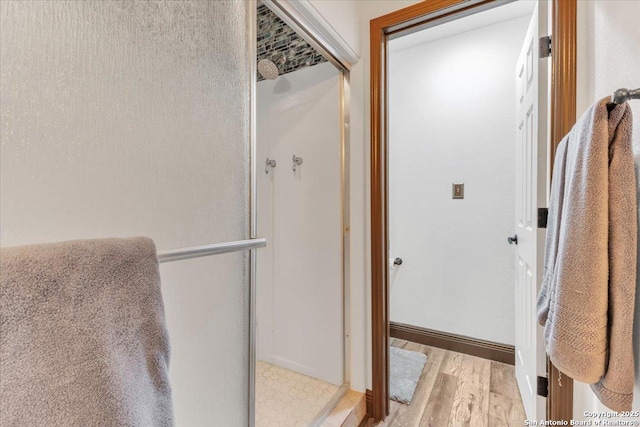 bathroom featuring an enclosed shower and wood-type flooring