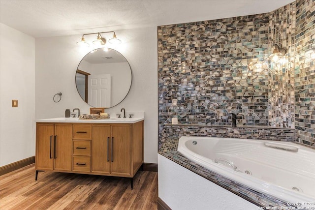 bathroom featuring vanity, a relaxing tiled tub, and wood-type flooring