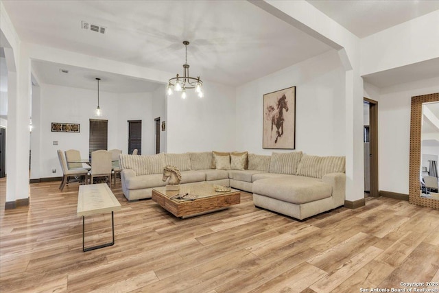 living room with light hardwood / wood-style floors and a chandelier