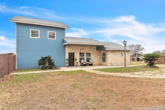 back of house with a patio and a lawn