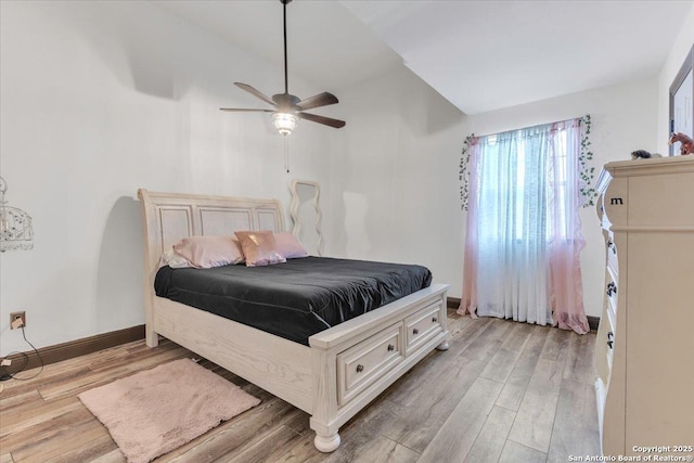 bedroom featuring ceiling fan, light wood-type flooring, and lofted ceiling