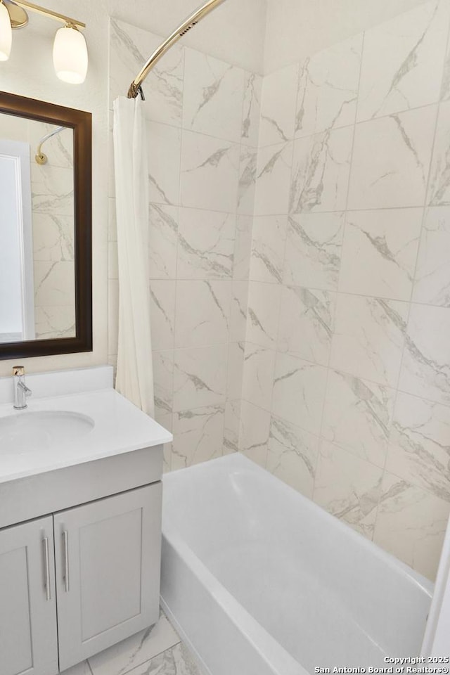 full bathroom with marble finish floor, shower / bath combo with shower curtain, and vanity