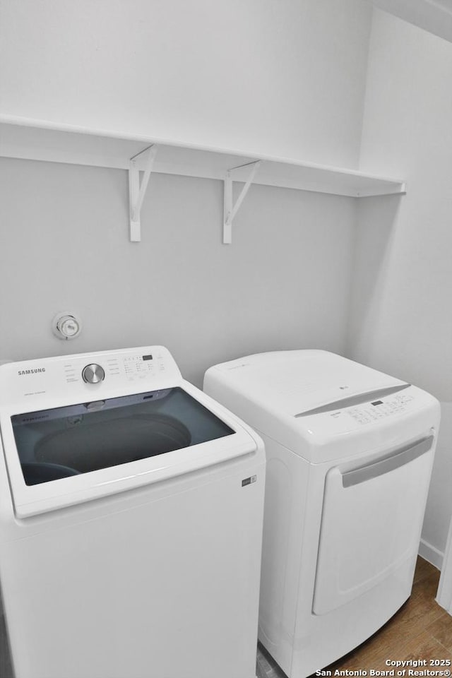 laundry room featuring washing machine and dryer, laundry area, and wood finished floors