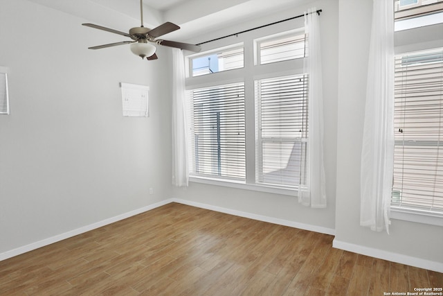 empty room with wood finished floors, ceiling fan, and baseboards