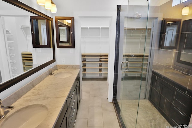 bathroom featuring a sink, tile patterned floors, double vanity, and a stall shower