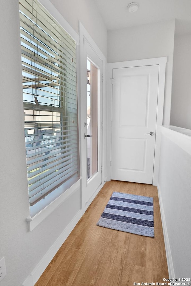 doorway to outside with baseboards and wood finished floors
