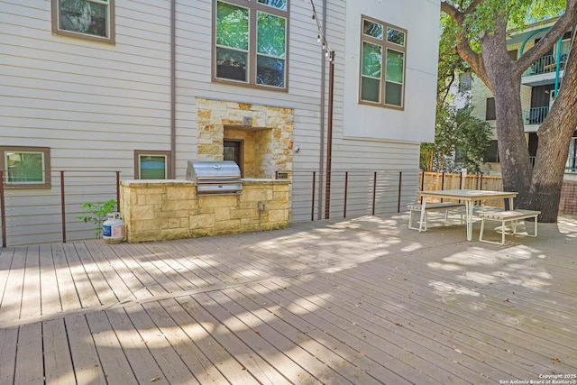wooden deck with area for grilling, fence, and outdoor dining area