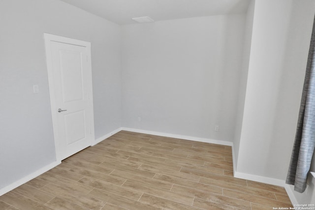 unfurnished room with light wood-style floors and baseboards