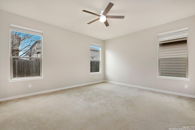 unfurnished room featuring light colored carpet, ceiling fan, and baseboards