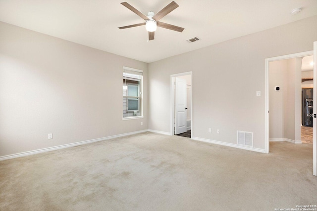 empty room with baseboards, a ceiling fan, visible vents, and light colored carpet