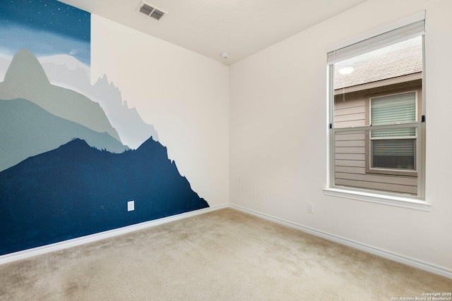 spare room featuring carpet floors, visible vents, and baseboards