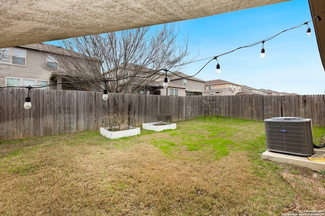 view of yard with central air condition unit, a garden, and a fenced backyard