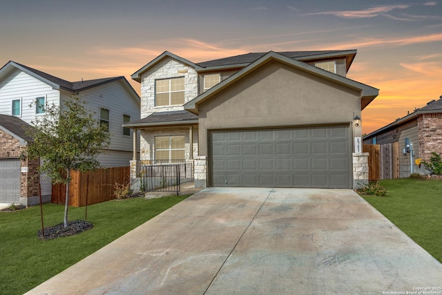 view of front of home featuring stone siding, a lawn, fence, and stucco siding