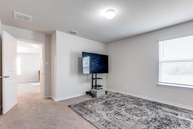 living room featuring baseboards, a textured ceiling, visible vents, and carpet flooring