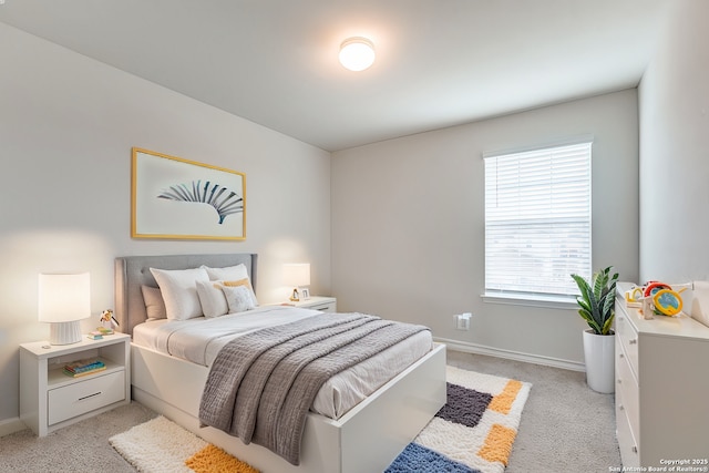 bedroom featuring light colored carpet and baseboards