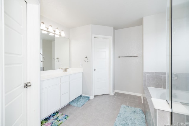 bathroom featuring tiled tub, vanity, and tile patterned floors