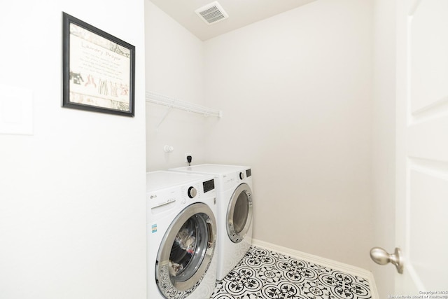 clothes washing area featuring washing machine and dryer and light tile patterned floors