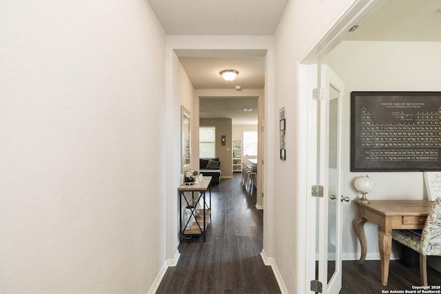 corridor with dark hardwood / wood-style flooring