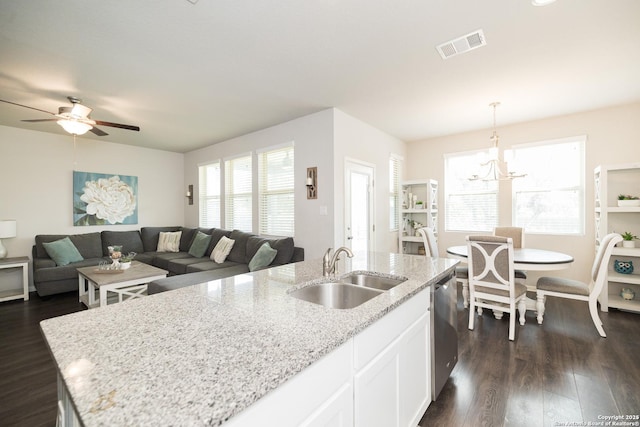 kitchen featuring hanging light fixtures, light stone countertops, sink, dishwasher, and white cabinets